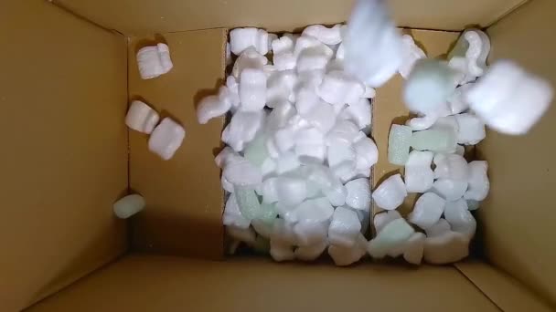 绿色泡沫橡胶和白色泡沫填充物落入纸板箱 — 图库视频影像