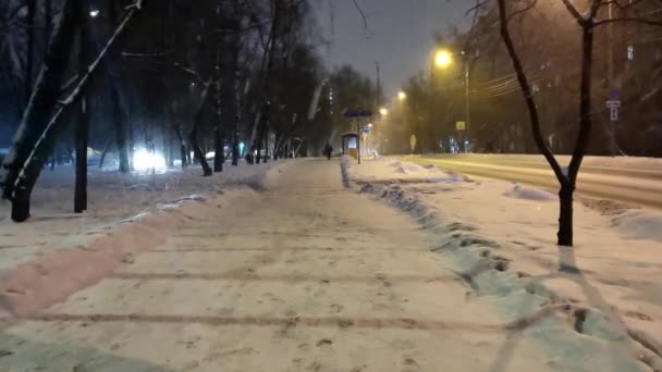 Cubierta de nieve calle de la noche de la ciudad, está nevando fuertemente — Vídeo de stock