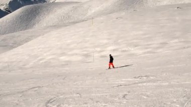 Bir snowboardcu yamaçtan geçiyor.