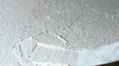 Kontrplak ve spatula üzerine beyaz granüler dekoratif alçı uygulaması