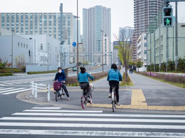 Bisikletli insanlarla yaya geçidi, koruyucu maskeler takan insanlar.