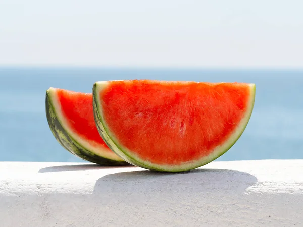 Two slices of watermelon on the background of the sea. Fotos De Stock