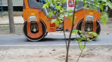 Asfalt kaldırım silindiri yeni dökülmüş asfaltın üzerinden geçiyor.