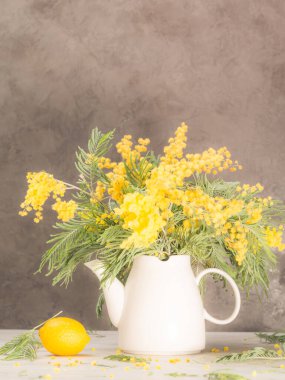 durgun hayat - akasya, beyaz çaydanlık ve limon, gri arka planda