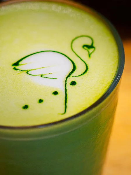 Latte art - dibujo de flamencos sobre espuma con té matcha caliente sobre leche de coco. — Foto de Stock