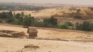 Sfenks 'in başına ve arkasındaki Giza şehrinin mezarlığına bakın.