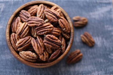 Siyah eski püskü bir tahtanın üzerinde yuvarlak bir tahta bardakta fındık fıstığı. Fındık ve tohum. - Sağlıklı yağlar. Fındık kabuklu cevizli diyet. Lezzetli çiğ organik atıştırmalıklar.