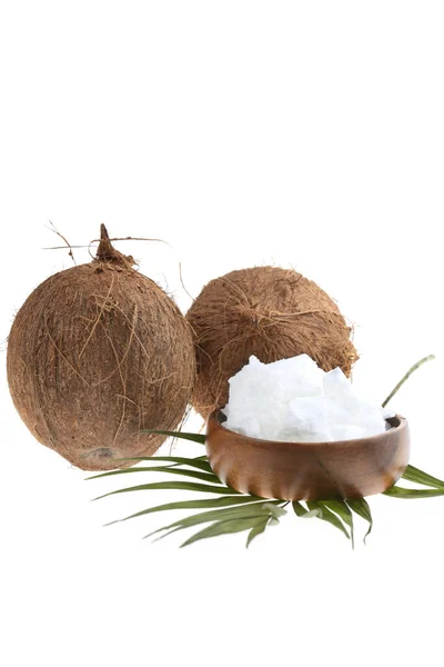 Organiczny olej kokosowy. Olej kokosowy w drewnianej filiżance i owoce kokosowe zbliżenie z liściem palmy izolowane na białym tle — Zdjęcie stockowe