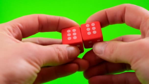 Szerencse és siker koncepció.Szerencsejátékok. Társasjátékok koncepció.Mérkőzés, azonos számok.Piros kockák kezében egy élénk zöld háttér. — Stock videók