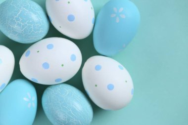 Paskalya tatili. Açık mavi arka planda mavi ve beyaz benekli yumurtalar. Pastel renklerde neşeli paskalya arkaplanı.