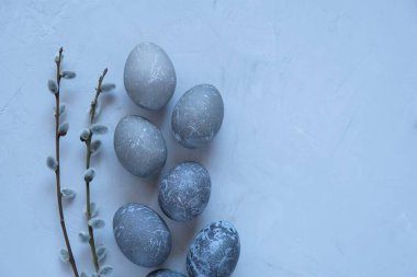  Easter gray marble eggs and branches of blossoming pussy willow on a concrete background. Spring religious holiday.Easter background in minimalist style
