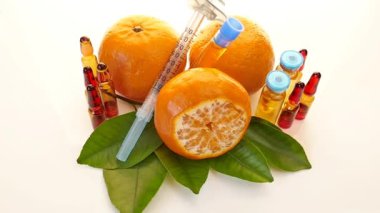 Ampul, şırınga, mandalina ve limondan oluşan C vitamini. Kozmetik kavramı.