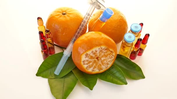 Vitamina C em ampolas, seringa, mandarina e limão em um fundo leve. — Vídeo de Stock