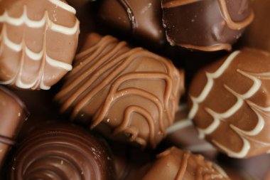 Çikolata takımı. Çikolata tatlısı. Çikolata desenli. Kahverengi arka planda şekerleme. Koyu sütlü çikolatalar. Farklı çikolatalardan.