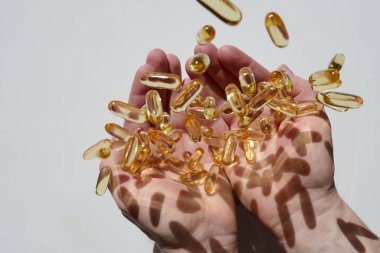 Balık yağı kapsülleri ayarlandı. Omega asitler. Beslenme takviyeleri. Omega-3 Şişko Acid. balık yağı jelatin kapsülleri beyaz bir arka planda erkeklerin elleri üzerinde yükselmeyi sağlar. Sağlıklı yiyecek ve yaşam tarzı..