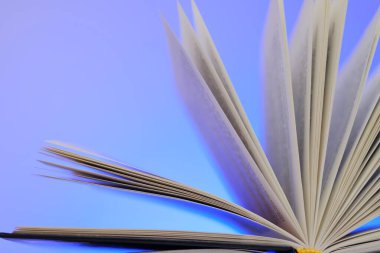 Kitap ve edebiyat okumak. Mavi arka plan üzerine açık bir kitap. Kitap sayfaları. Öğrenme ve bilgi kavramı..