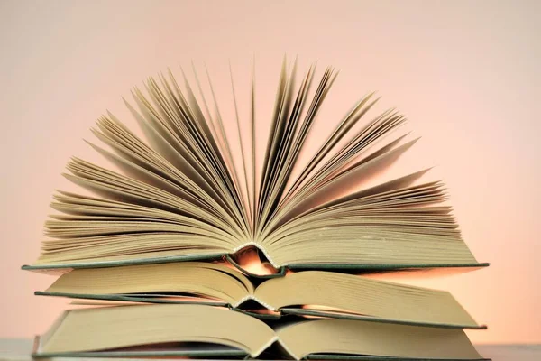 Reading books and literature.Open books stack on a light pink background. Study and education concept. Close-up book pages.Learning and knowledge — Stock Photo, Image