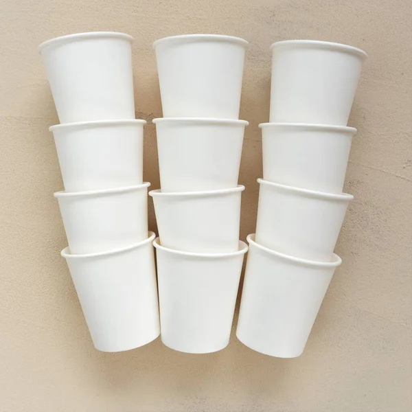 Cups.tableware from paper. Disposable beige cups on beige background.plastic free .Bamboo organic cups. Ecology recycling concept. Empty paper cups mockup.Zero waste