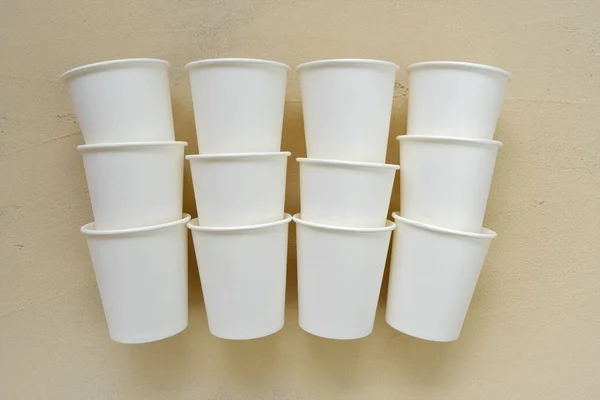 Cups készült biológiailag lebomló papír.Asztali áruk papírból. Eldobható bézs csésze bézs háttér. Műanyag mentes. Bambusz szerves csésze. Ökológia újrahasznosítási koncepció. Üres papírpoharak mockup. Zéró hulladék — Stock Fotó