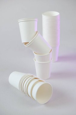 Plastiksiz tek kullanımlık sofra takımı. Sıfır atık, plastiksiz. Bambu organik bardaklar. Beyaz kağıt bardaklar bej arka planda. Kağıt bambu bardakları seti. Geri dönüşüm konsepti. Çevre dostu sofra takımı