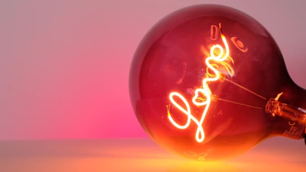 Valentines Day. Pink Light bulb with the inscription love on a pink background.Love concept. Love and relationship symbol. — Stock Video