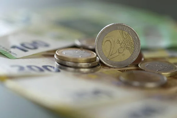 Monedas en euros y billetes en euros sobre un fondo verde.Dinero. Dos monedas de euro. Moneda europea. Finanzas y ahorros. — Foto de Stock
