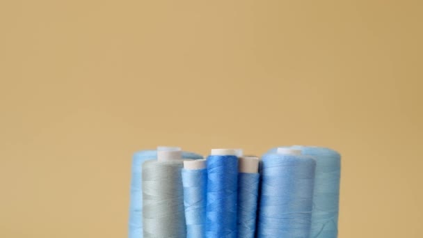 Blue threads set on a beige background.Sewing and handicraft concept. rotation.A set of threads blue colors — Stock Video