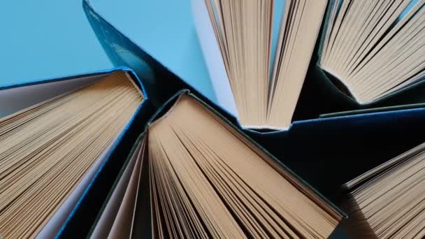 Libros sobre fondo azul.Lectura de libros.Conocimiento y aprendizaje.Primeros planos de las páginas del libro.Concepto de lectura y educación.Estantería. — Vídeos de Stock