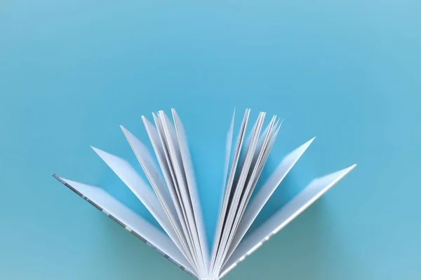 Book on a blue background.Reading and education concept. Knowledge and Learning. Reading of books. Book pages close-up.Knowledge and education.