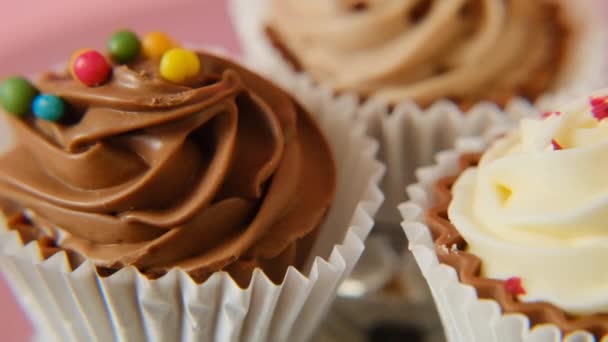 Bolinhos de creme. bolos de chocolate em um fundo rosa. Doces e sobremesas. — Vídeo de Stock
