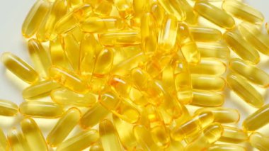 Arka planda balık yağı var. Dönüşümlü. Omega yağ asitleri. Doğal takviyeler ve vitaminler. Sağlıklı beslenme ve gıda takviyeleri.