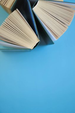 Mavi bir arkaplan üzerine kitaplar. Kitap okumak. Bilgi ve öğrenim. Bilgi ve eğitim. Kitap sayfaları.