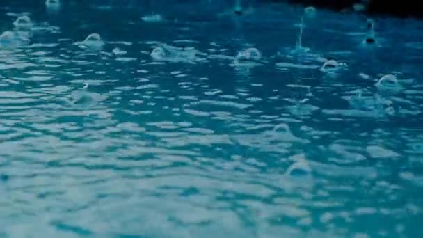 Gotas de agua. Burbujas de agua y gotas textura. El agua es azul con gotas de lluvia. Movimiento lento. — Vídeo de stock