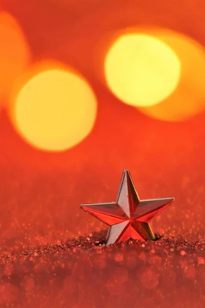 Різдвяний та новорічний фон. Червона зірка в блискучому золотому блиску на червоному розмитому фоні. Різдвяні шпалери — стокове фото