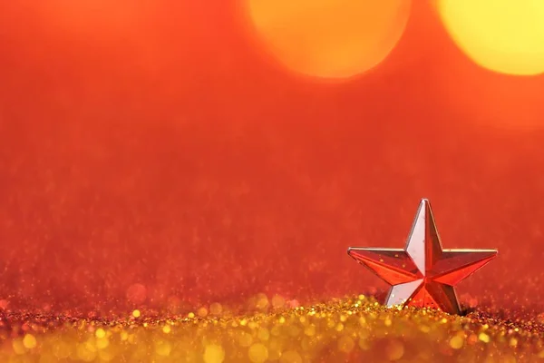 Noel arkaplanı. Kırmızı, parlak altın parıltılı bir yıldız, bulanık bir arka planda. Noel tatili duvar kâğıdı. — Stok fotoğraf