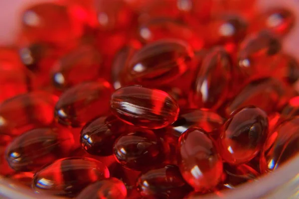 Krill oil capsules background.omega fatty acids.Red capsules with krill oil. Natural supplements and vitamins.