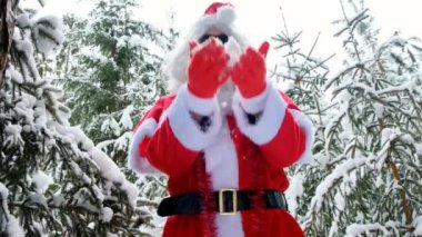 Neşeli Noel Baba karla oynuyor. Noel Baba 'nın kış eğlencesi. Noel zamanı. Kış ormanında. Noel Baba kar yağdırır.
