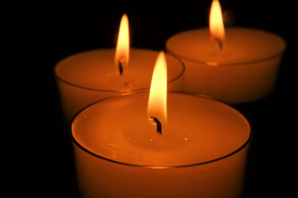 Свічка полум'я. Набір білих свічок. Спалювання свічок у темряві. Закриття полум'я свічки . — стокове фото