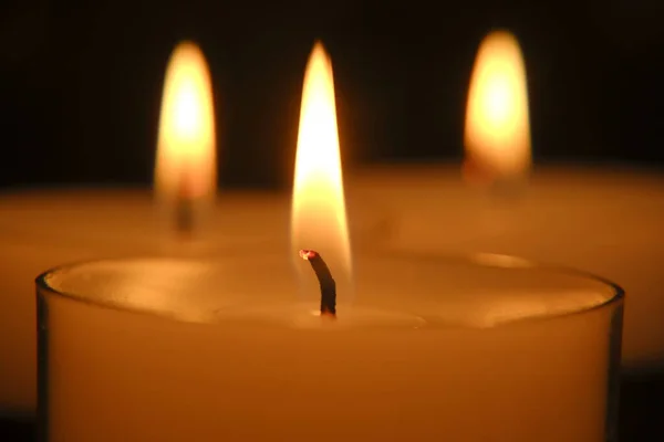 Flamme de bougie. bougies blanches. Brûler des bougies dans l'obscurité Gros plan flamme de bougie. — Photo