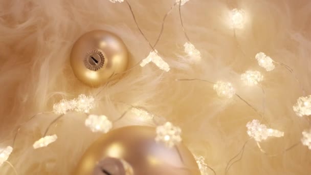 Weihnachtlicher Hintergrund mit Girlanden und goldenen Kugeln auf beigem Fell in warmen Farben. Winter gemütliche Stimmung.Winterurlaub Hintergrund. — Stockvideo
