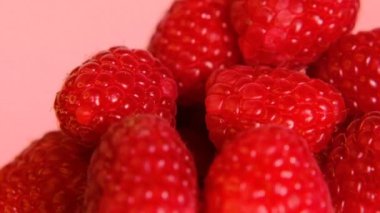 Pembe arka planda olgun ahududu. Ahududu çileği yakından. Sağlıklı bir tatlı. Rotasyon. Kızıl Çiftlik biyolojik ürünleri