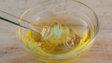 Bal dokusu. Ballı şeker. Cam bardak, cam bardaktaki bal için. Tahta bir masada.