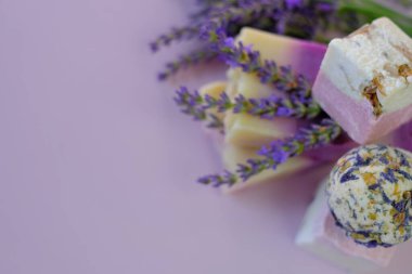Lavanta banyosu, sabun, lavanta çiçekleri ve mor bir arka plan. Spa ve aromaterapi. Lavanta özü ile organik bitkisel kozmetik. Güzellik ve rahatlama. 