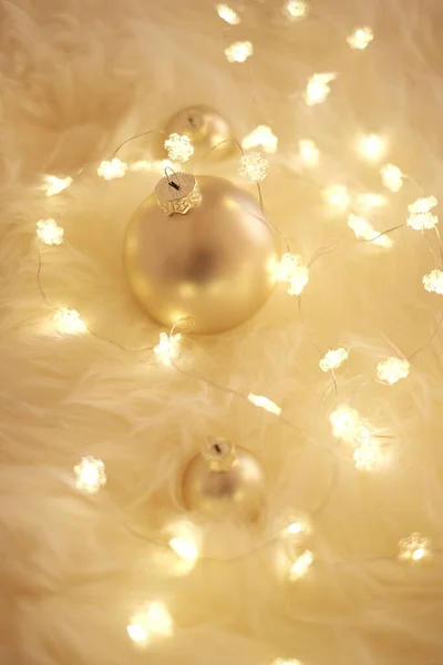 Noel arkaplanı, parlak çelenkler ve bej kürkünde sıcak renklerde altın toplar. Kış havası. Kış tatili. Kış tatili. — Stok fotoğraf