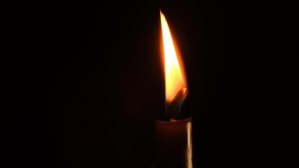 Fiamma di candela al buio. Luce della candela su sfondo nero. — Video Stock