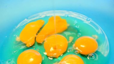 Çiğ yumurta. Yumurta beyazı ve yumurta sarısı. Yumurta akar ve fincanın içine düşer..