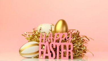 Pembe arka planda mutlu paskalyalar. Dini bayram geçmişi. Yuvadaki altın Paskalya yumurtaları ve yazıtlar Mutlu Paskalya tatili