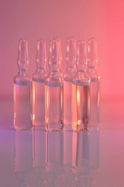 Biyolojik evrim tedavisi, mezoterapi çözeltisi. Biyoteknoloji ve bilim. İlaç ve eczacılık. Pembe ışıkta şeffaf aparatifler. Aşı ve ilaç..