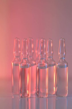 Biyolojik evrim tedavisi, mezoterapi çözeltisi. Enjeksiyon için çözüm. Biyoteknoloji ve bilim. Tıp ve Farmakoloji. Pembe ışıklı apkatırlar. Aşı ve ilaç..