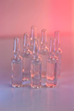 Enjeksiyon için çözüm. Biyolojik evrim tedavisi, mezoterapi çözeltisi. Biyoteknoloji ve bilim. İlaç ve eczacılık. Pembe ışıkta şeffaf aparatifler. Aşı ve ilaç..